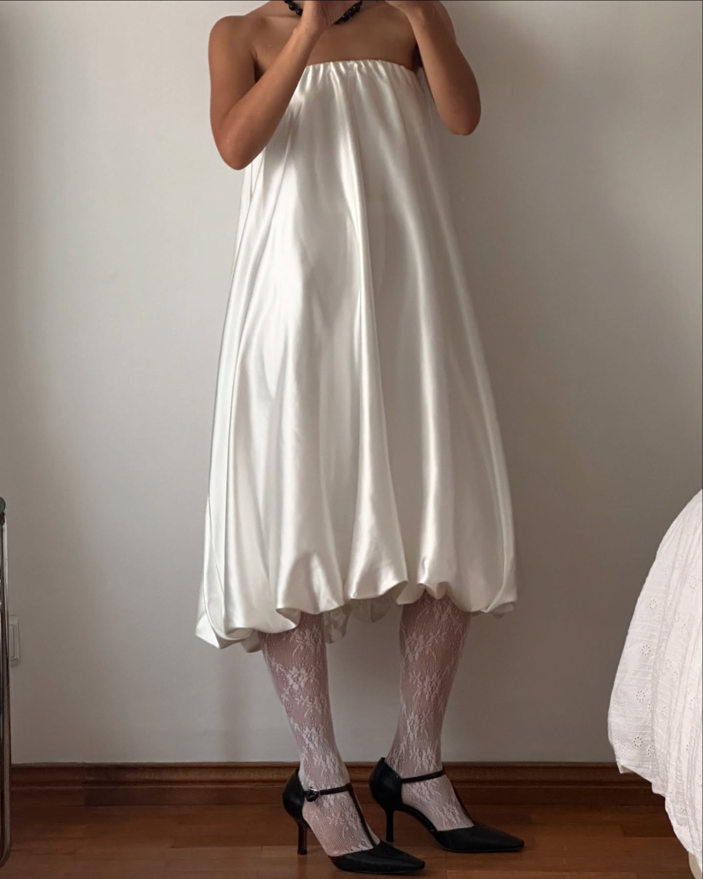 Influencer @deborabrosa wears white lace tights with a white bubble dress and black t-bar heels.