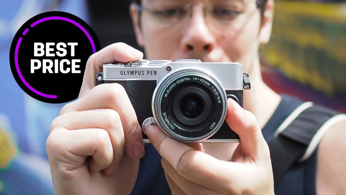 Close-up of photographer James Artaius holding an Olympus PEN E-P7, with the text &quot;Best price&quot;