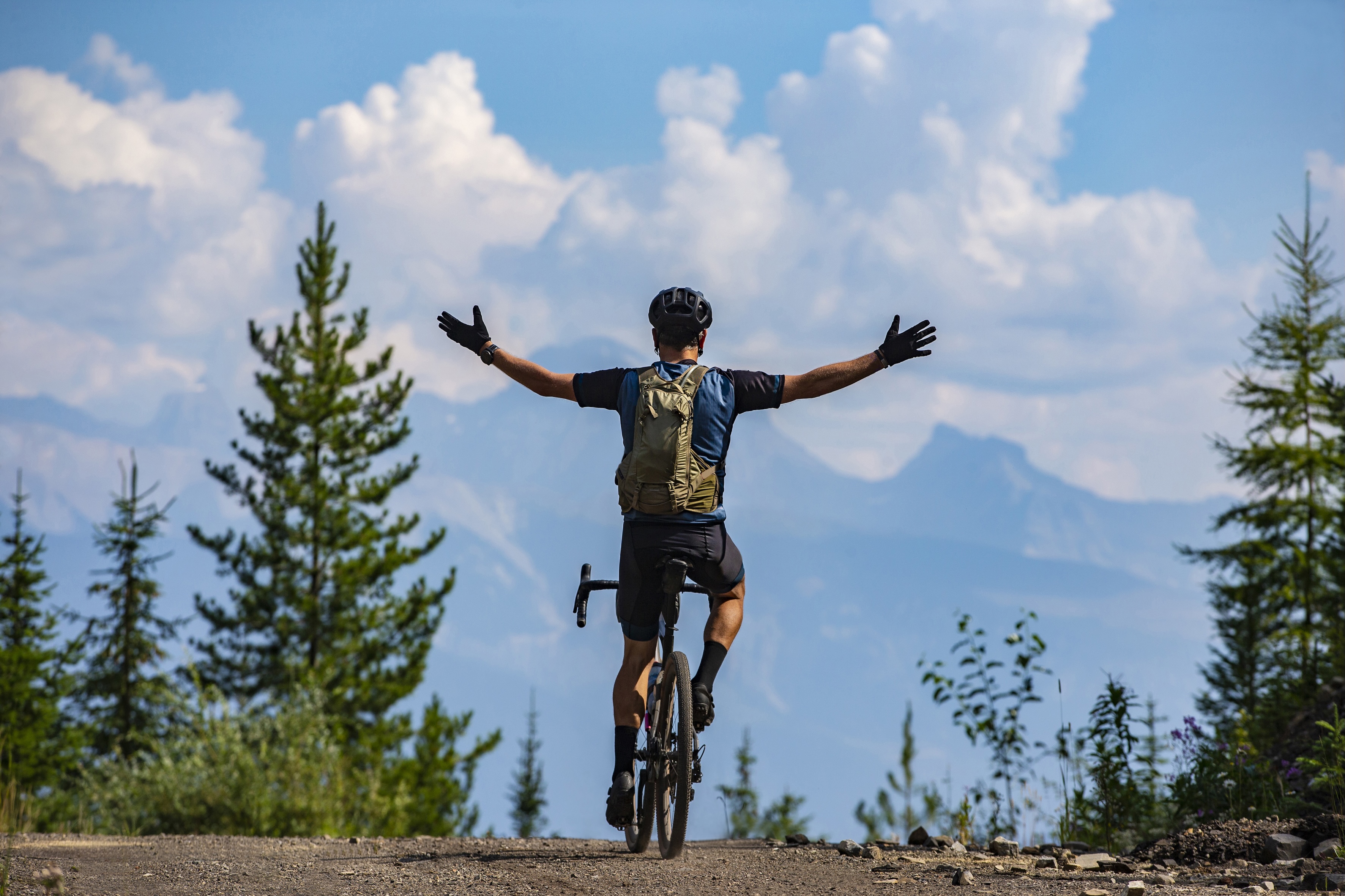 Man riding a bike in front of a mountains vista