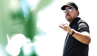 Mickelson catches a golf ball while wearing sunglasses