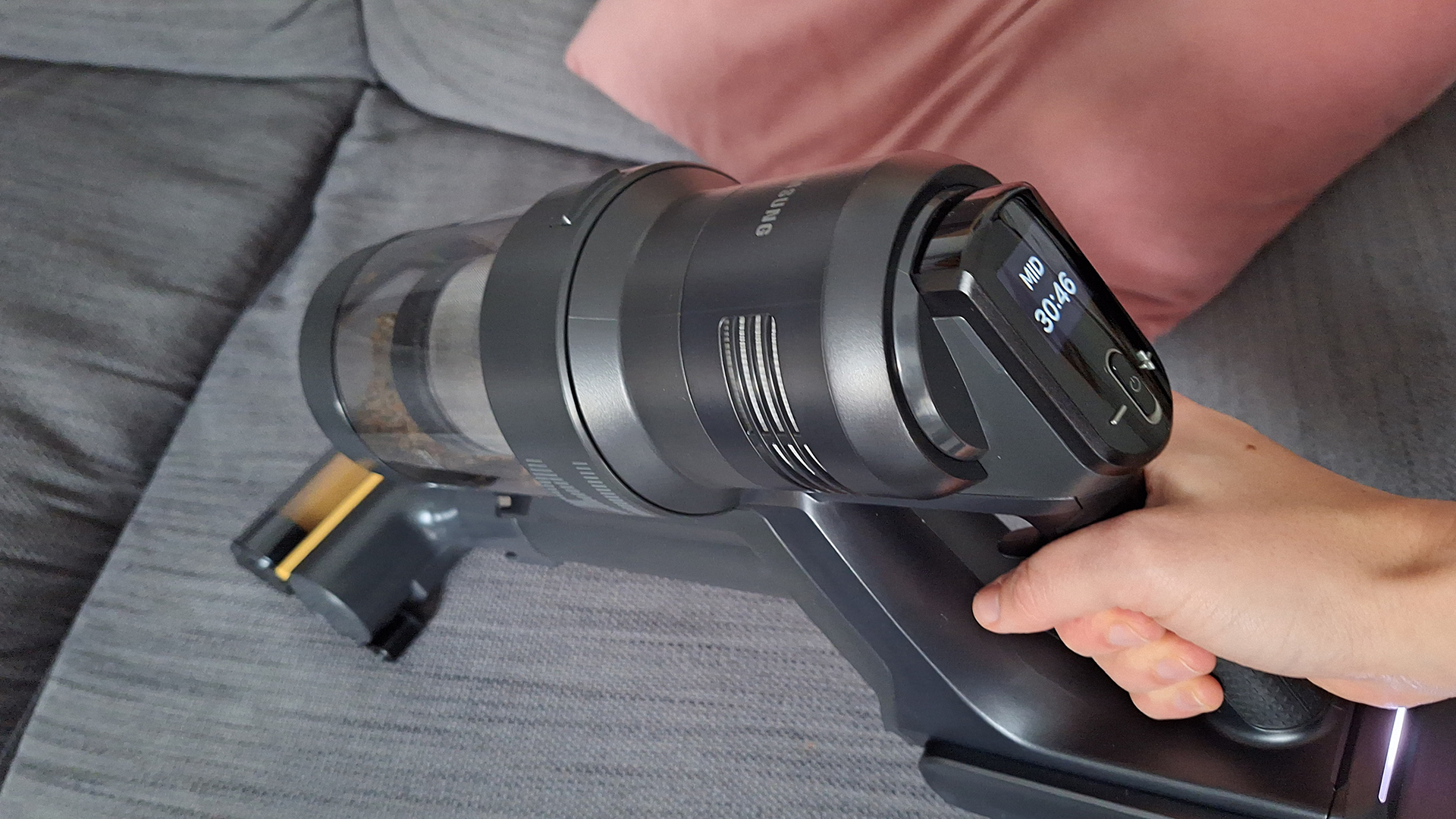 Samsung Bespoke AI Jet Ultra in handheld mode on reviewer's sofa