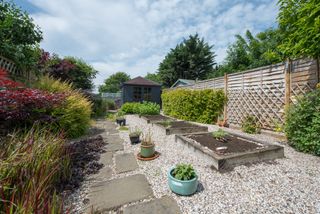 gravel garden with raised beds and summer house