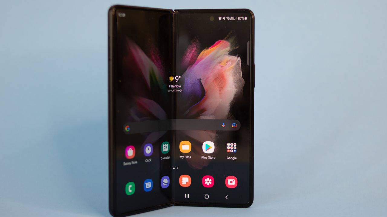 A photograph of the Samsung Galaxy Z Fold 3 unfolded and stood on a table