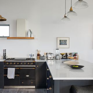 White kitchen with black peninsula island and cooker