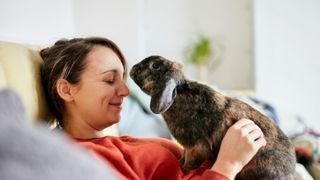 Woman sitting with rabbit in her lap
