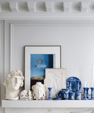 wedgewood blue pottery on mantelpiece with candlesticks