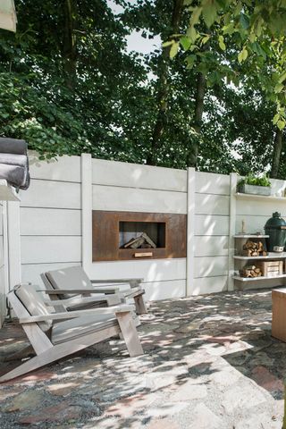 patio garden with wall mounted fireplace and cosy seating