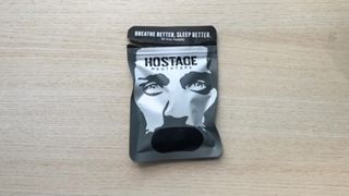 The front of the package of Hostage Mouth Tape showing a graphic of a man with black tape over his mouth