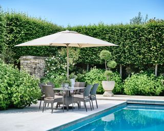 pool patio with outdoor dining set and cream parasol