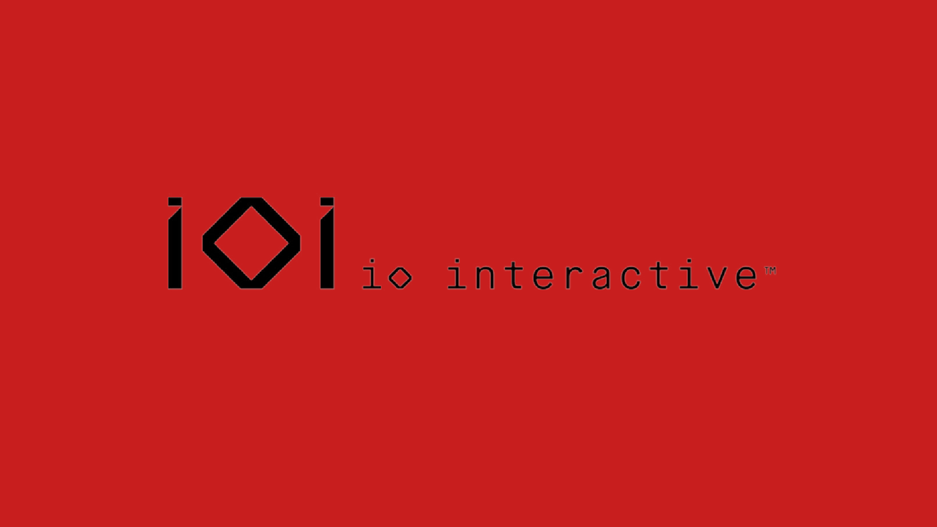 IO Interactive logo displayed in black against a solid red background, representing the studio behind Hitman, 007: First Light, and Project Fantasy.