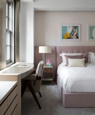 a modern art deco bedroom in soft shades. A built in desk overlooks a window