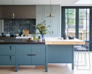 roost episode 6 - wood and black granite kitchen worktops in a blue kitchen with seating - Credit-Mowlem-and-Co