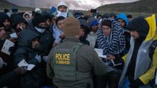 TOPSHOT - Asylum seekers rush to be processed by border patrol agents at an improvised camp near the US-Mexico border in eastern Jacumba, California, on February 2, 2024. (Photo by Guillermo Arias / AFP) (Photo by GUILLERMO ARIAS/AFP via Getty Images)