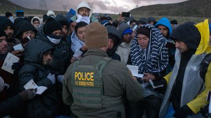 TOPSHOT - Asylum seekers rush to be processed by border patrol agents at an improvised camp near the US-Mexico border in eastern Jacumba, California, on February 2, 2024. (Photo by Guillermo Arias / AFP) (Photo by GUILLERMO ARIAS/AFP via Getty Images)