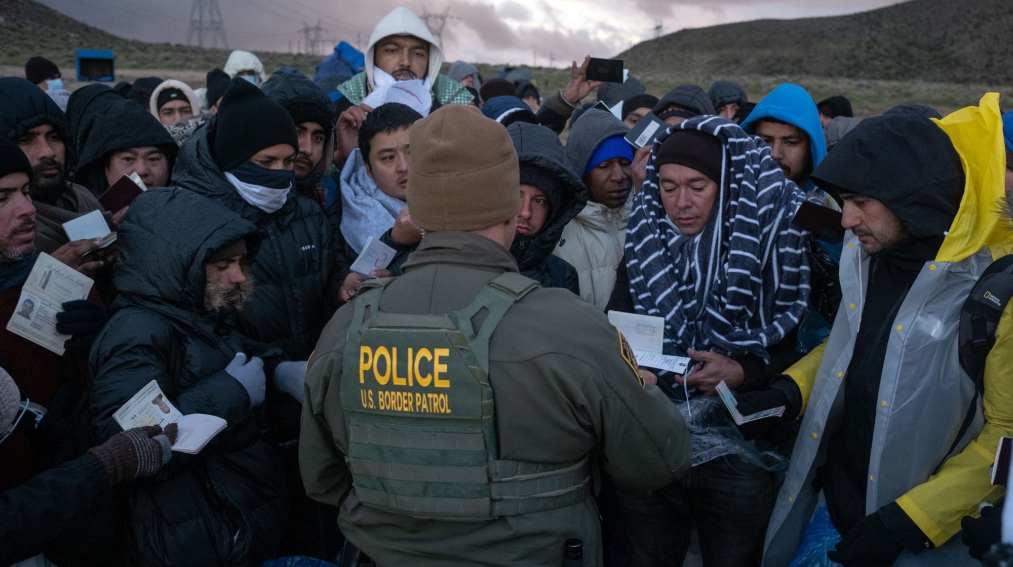 TOPSHOT - Asylum seekers rush to be processed by border patrol agents at an improvised camp near the US-Mexico border in eastern Jacumba, California, on February 2, 2024. (Photo by Guillermo Arias / AFP) (Photo by GUILLERMO ARIAS/AFP via Getty Images)