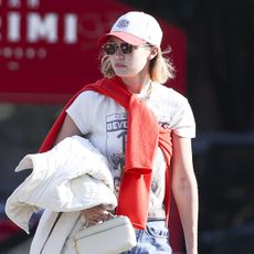 Gigi Hadid wearing a red sweater and baseball cap