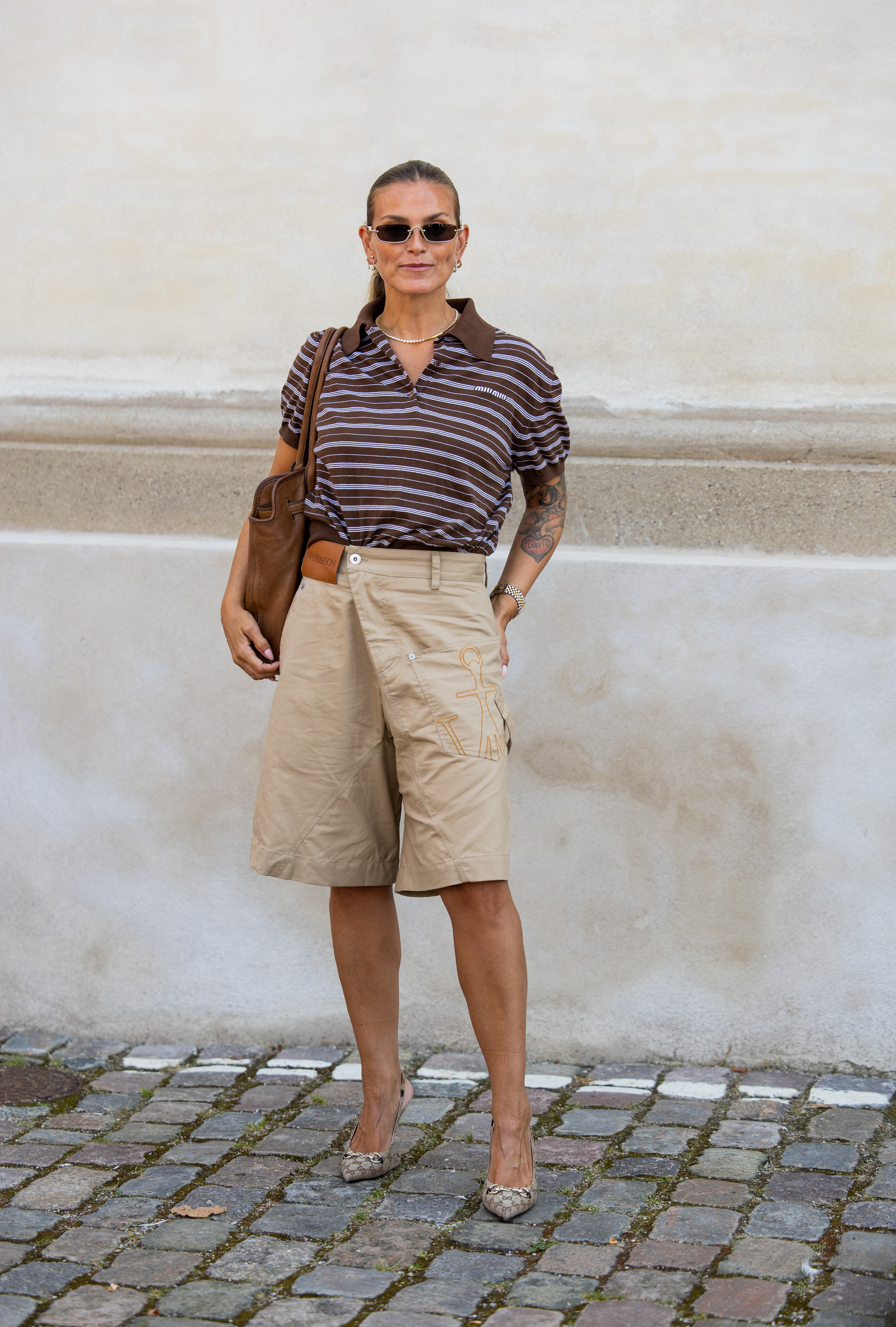 woman wearing striped shirt, bermuda shorts, and heels