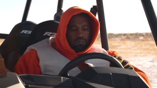 Kanye West behind the wheel of a jeep in music video for Follow God