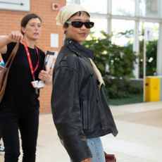 Taylor Russell wears a leather jacket, jeans and kitten heel sandals.