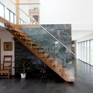 hallway with grey tiled flooring and wooden staircase