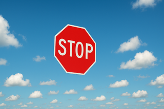 A stop sign is flying in blue skies