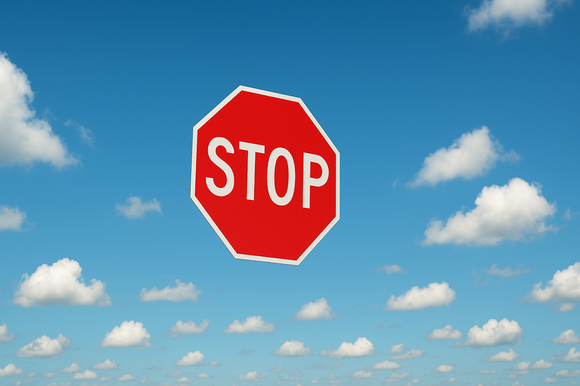 A stop sign is flying in blue skies