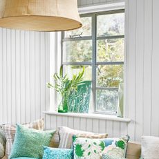 Window seat surrounded by white living room wall panelling ideas