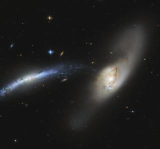 Galaxy NGC 2799 (on the left) and galaxy NGC 2798 (on the right) form a "galactic waterfall," which stands out in this image snapped by the Hubble Space Telescope. These are interacting galaxies, which influence each other and may eventually even merge.