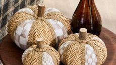 Set of 3 light brown check and rattan pumpkins on a wooden table