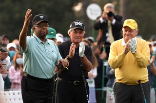 Lee Elder waves to the crowd and is applauded by Gary Player and Jack Nicklaus