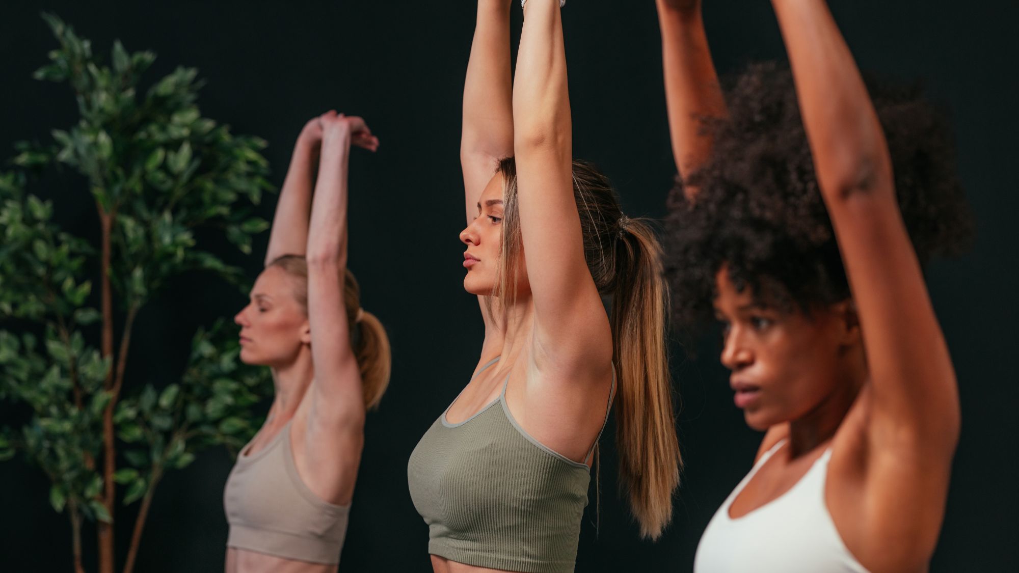 Three women in a yoga studio doing one of the best workouts for beginners