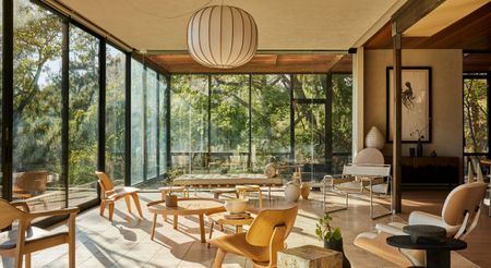 The home's primary living space opens seamlessly to the surrounding canopy, balancing artisanal details, refined furnishings, and a profound connection to nature.