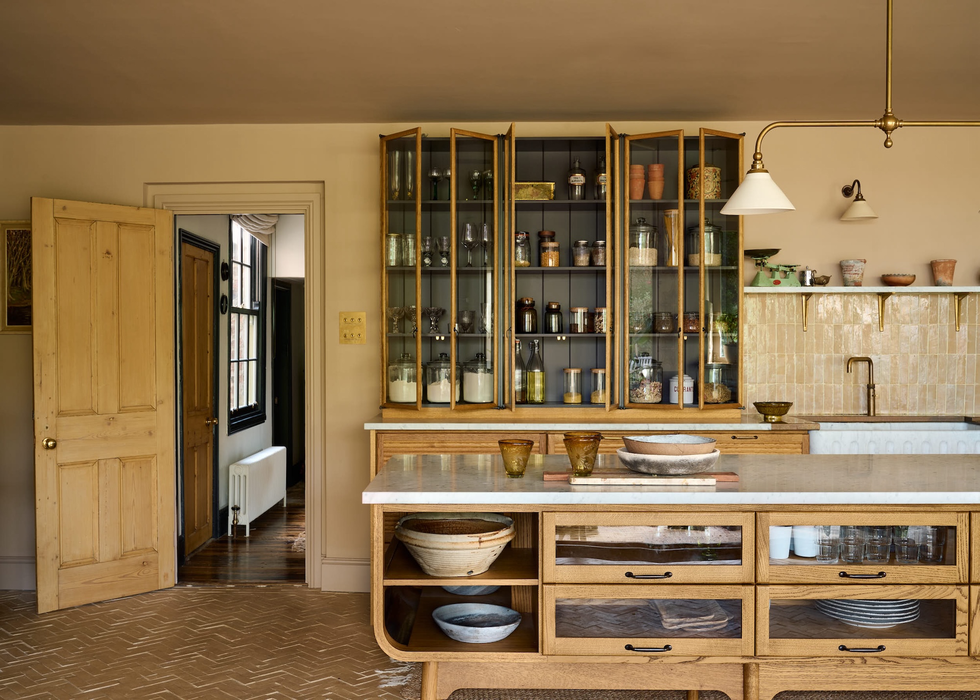 a kitchen island with glass fronted and open storage space