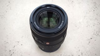 The Sony FE 50mm f/1.4 lens on a white marble table.