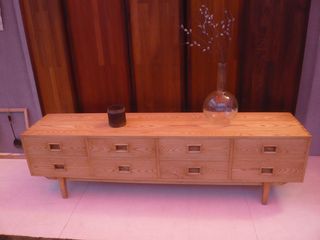 A low, wooden TV cabinet with eight drawers