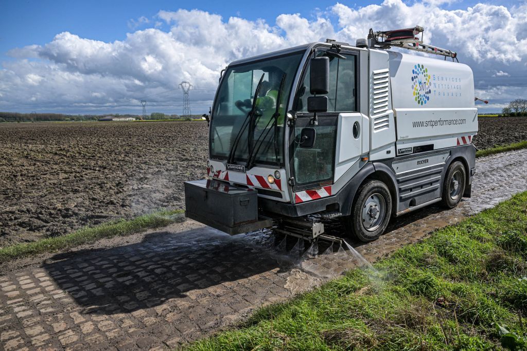 A road cleaning vehicle is pictured in action during the reconnaissance of the track ahead of this year's Paris-Roubaix cycling race, Friday 05 April 2024, around Roubaix, France. The Paris-Roubaix cycling races will take place this weekend, with the women riding on Saturday and the men on Sunday. BELGA PHOTO JONAS ROOSENS (Photo by JONAS ROOSENS / BELGA MAG / Belga via AFP)