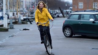 Woman riding a bike with a bright yellow jacket on