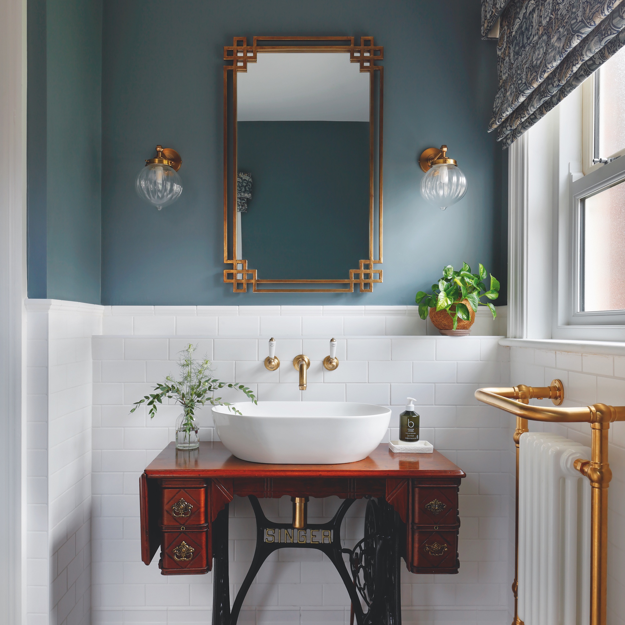 cloakroom bathroom with vanity unit made from vintage sewing machine table with over counter basin and mirror above