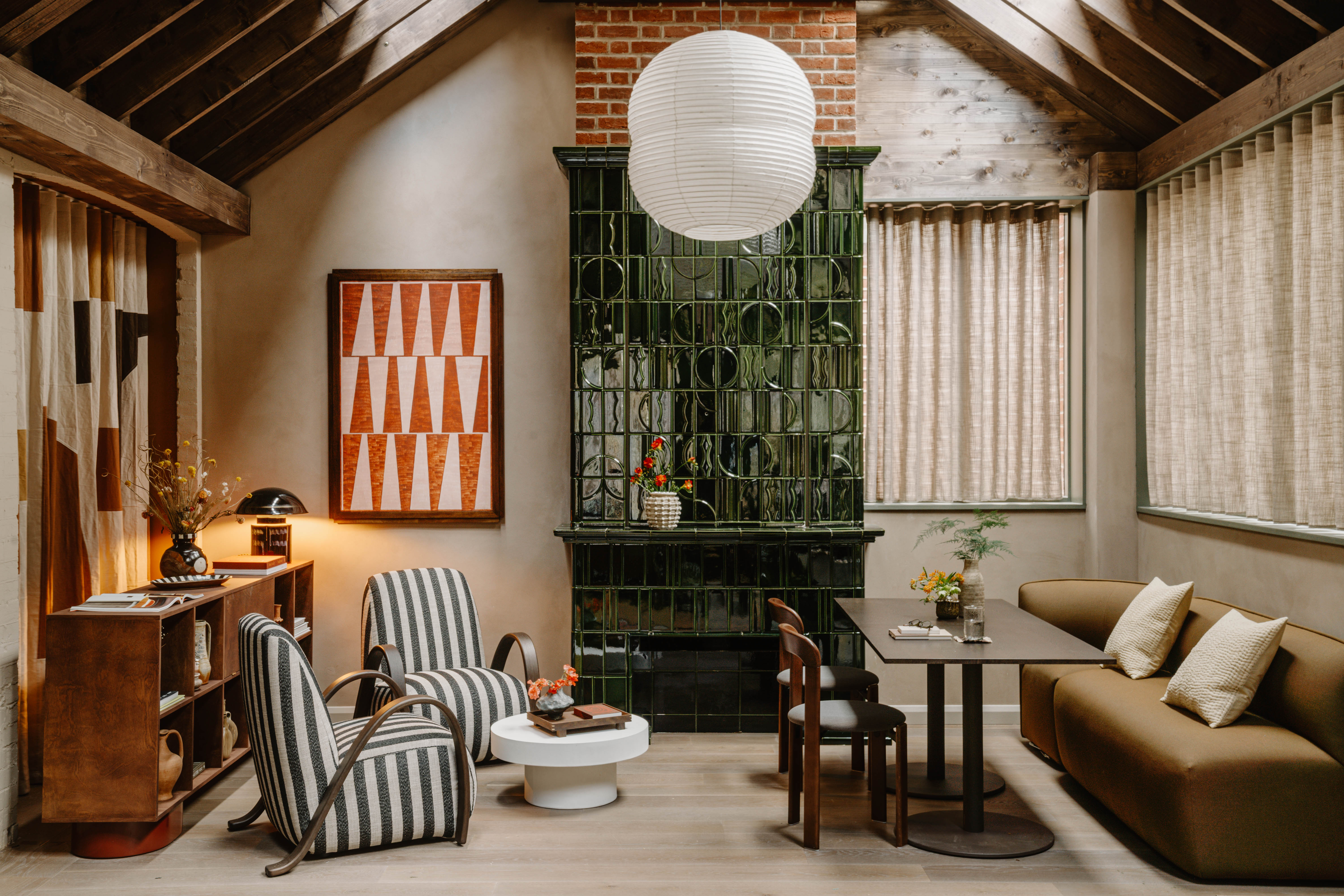 A neutrally tinted hotel with argilla-toned walls, sculptural furnishings, wooden surfaces, and curated art and tilework.