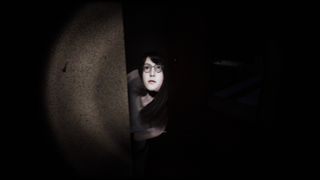 A girl peeks around a corner in a dark room