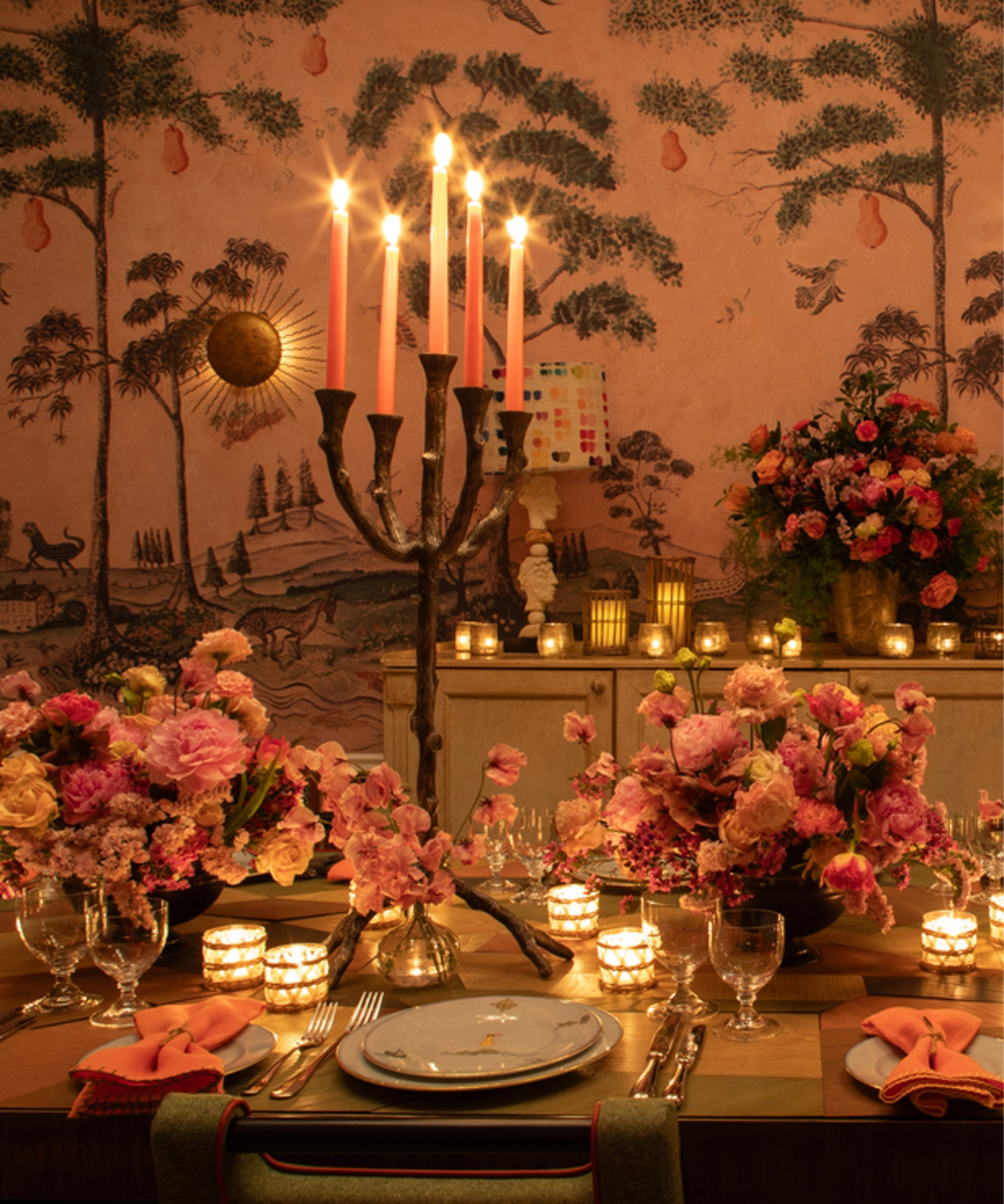 Orange table setting with flowers and glowing candlelight