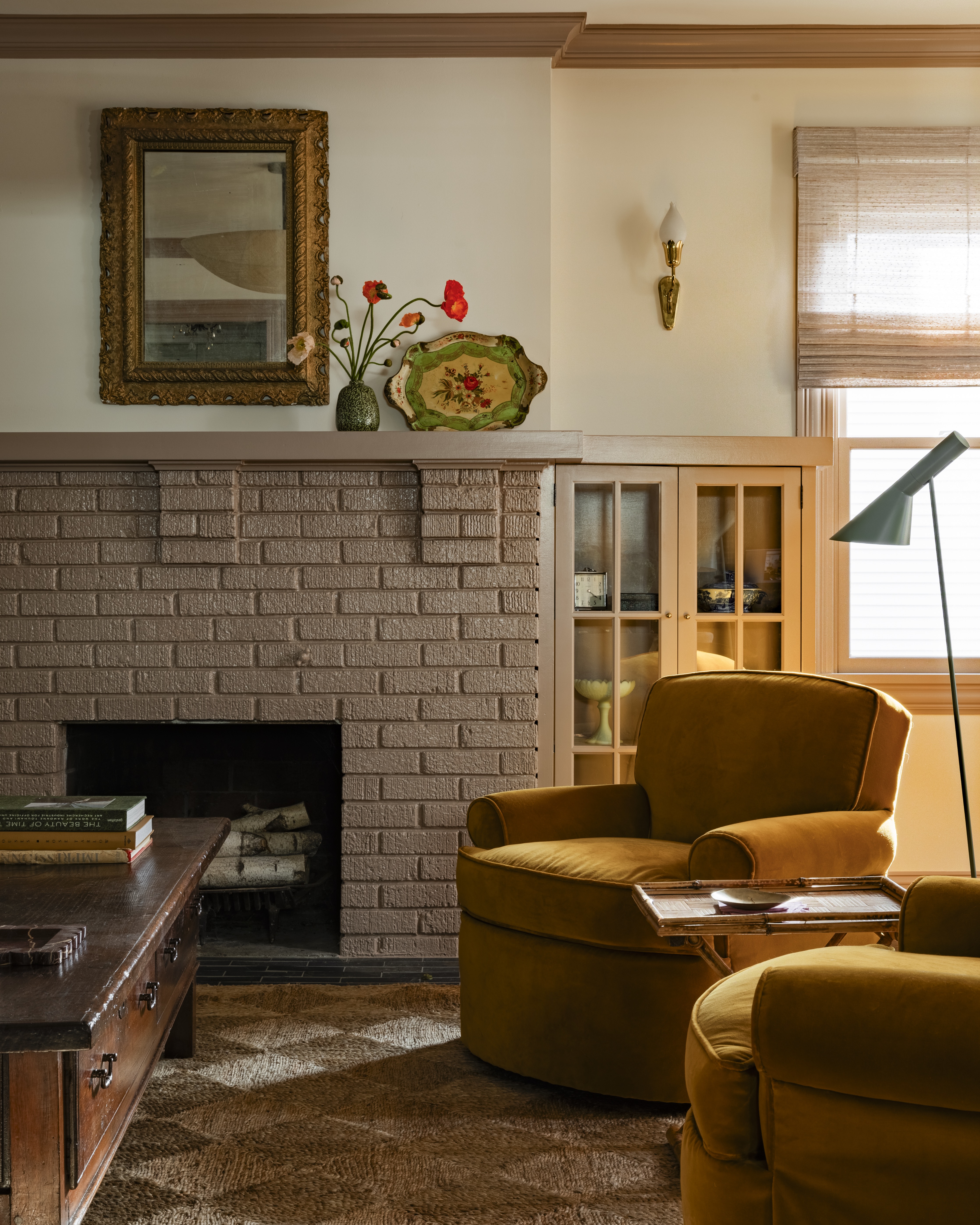 A fireplace in brick, with wooden cabinets next to it