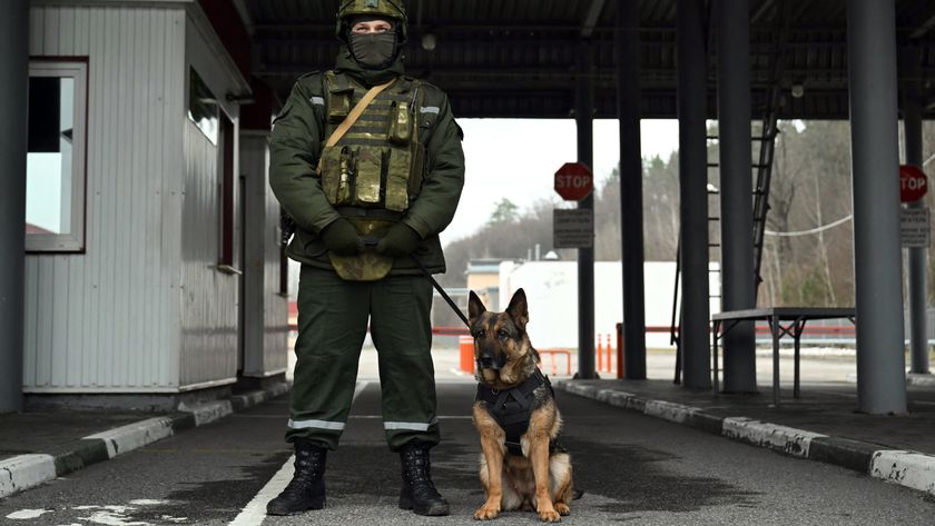 A Belarusian border guard with a service dog