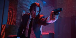 Keanu Reeves as John Wick holding gun