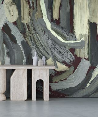 Expressive mural-style wallpaper behind a stone console