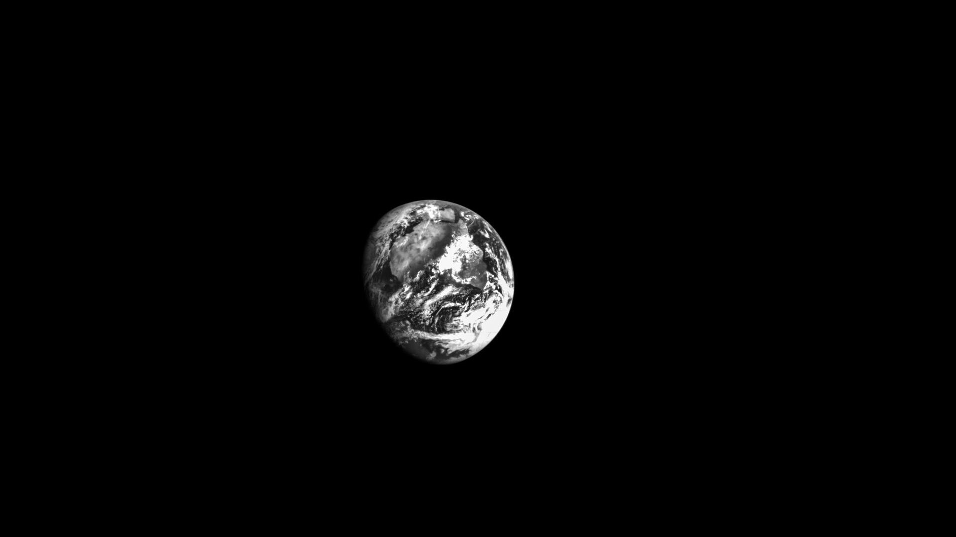 earth at a distance in black and white surrounded by black of space