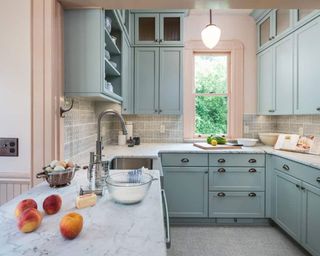Two-tone U-shaped pastel kitchen in blush pink and powder blue