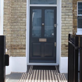 Black front door design with black and white floor tiles.