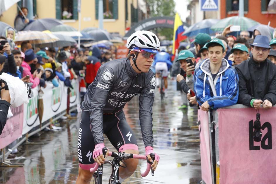 Bob Jungels' pink jersey is covered by hit wet weather gear