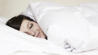 Woman asleep wrapped up in duvet